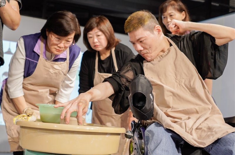 重度肢體障礙的阿琮以右手拇指與食指精準捏製容器